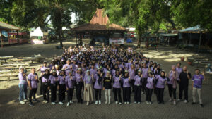 Rombongan peserta gathering kantor di lokasi outbound, berkumpul di lapangan outdoor